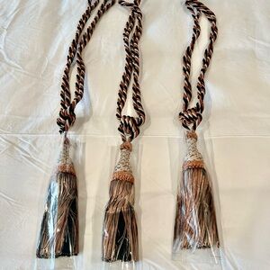 Set of three vintage French tassle curtain tiebacks with brass wall brackets.